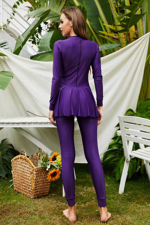 a woman in a purple suit standing in front of a white bench