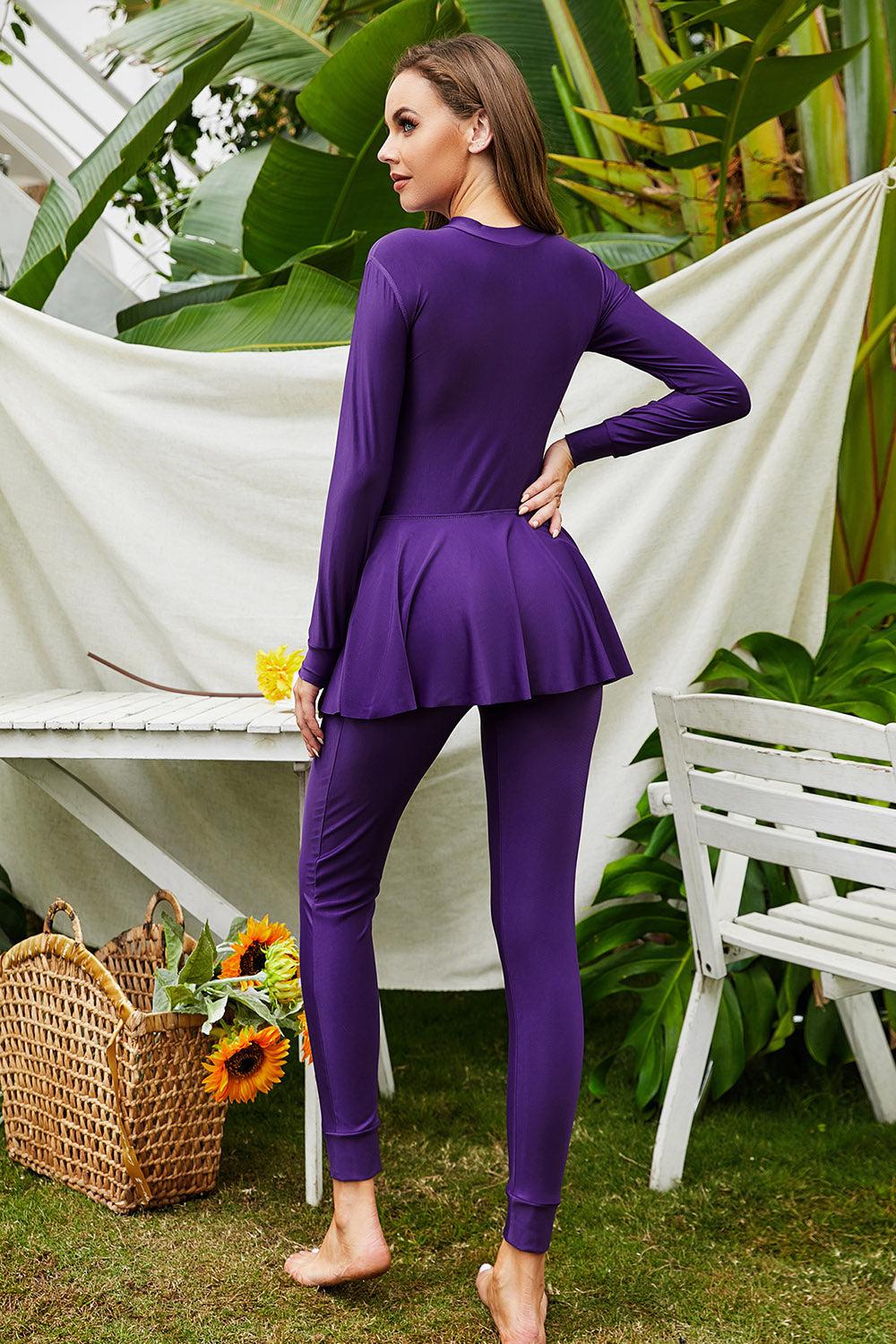 a woman in a purple outfit standing in front of a table