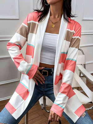 a woman sitting on a chair wearing a striped cardigan