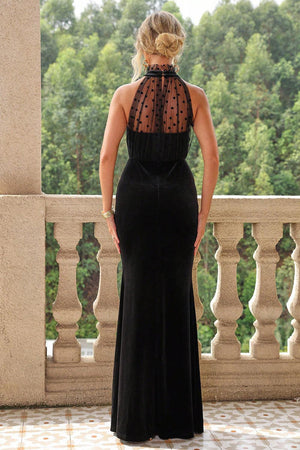 a woman in a black dress standing on a balcony