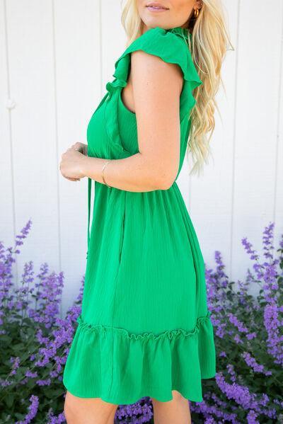 a woman in a green dress posing for a picture