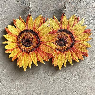 a pair of sunflower earrings hanging from a hook