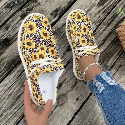 a woman's feet wearing yellow leopard print shoes