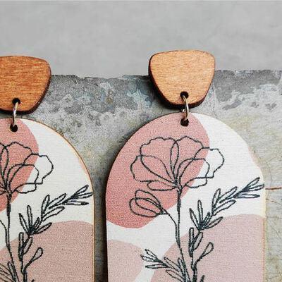 a pair of wooden earrings with flowers painted on them