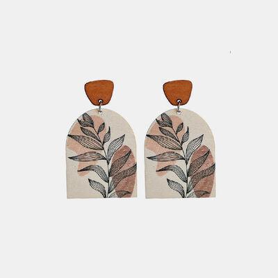 a pair of wooden earrings with leaves on them