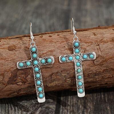 a pair of cross earrings with turquoise stones