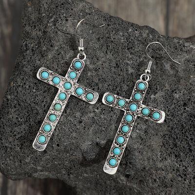 a pair of cross earrings with turquoise stones