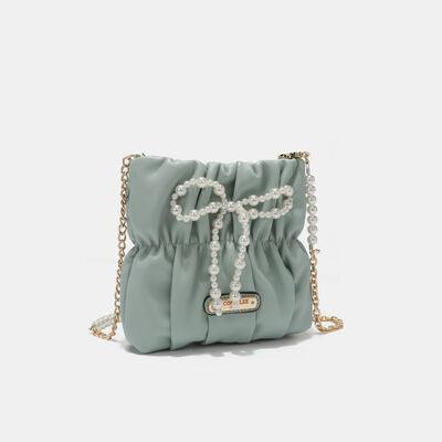 a handbag with pearls and a chain