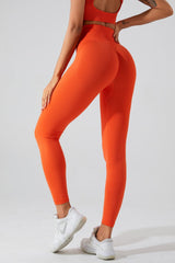 a woman in an orange sports bra top and leggings