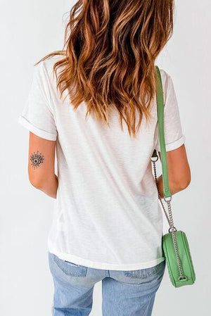 a woman in a white shirt is holding a green purse