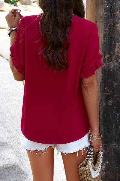 a woman wearing a red top and white shorts