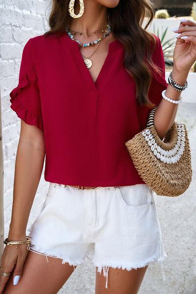 a woman wearing a red top and white shorts