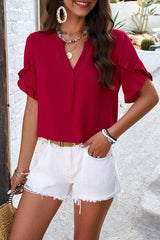 a woman wearing a red top and white shorts