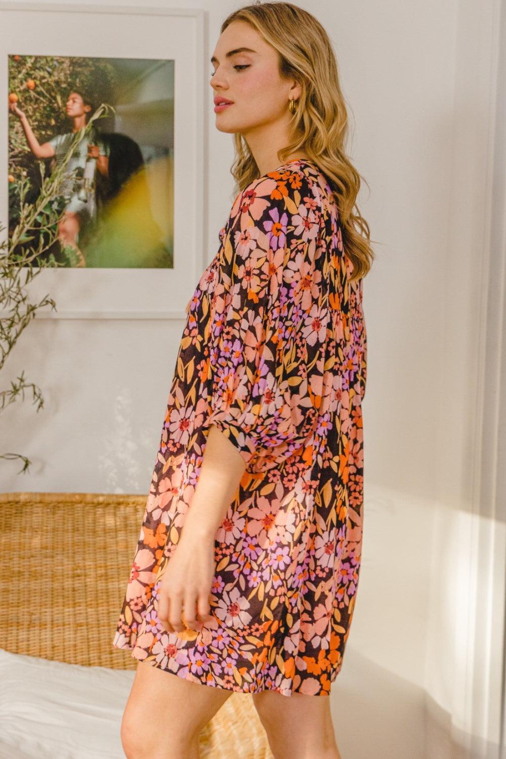 a woman in a floral dress standing on a bed