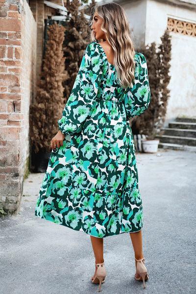 a woman wearing a green floral print dress