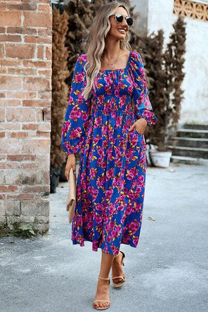 a woman in a blue and pink floral print dress