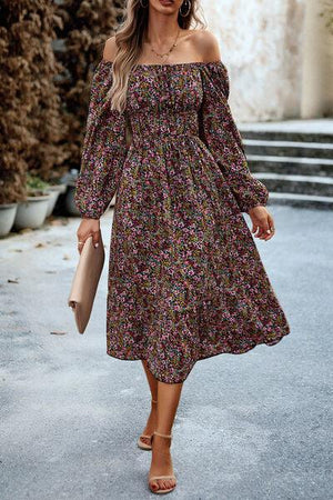 a woman in a floral dress is walking down the street