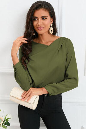 a woman wearing a green blouse and black pants