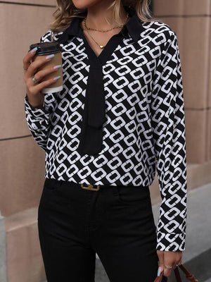 a woman in a black and white shirt holding a cell phone