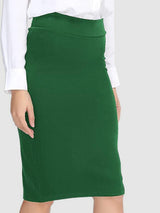 a woman in a white shirt and green skirt