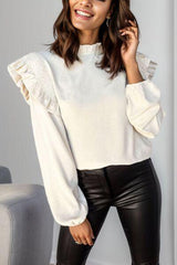 a woman wearing black leather pants and a white sweater