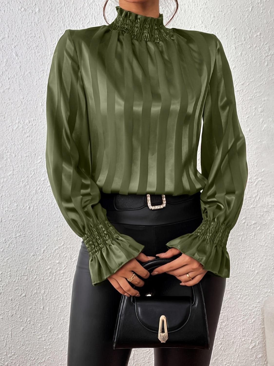 a woman wearing a green blouse and black pants