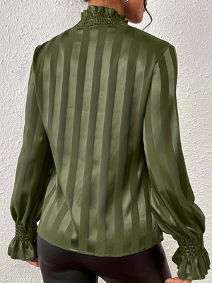 a woman wearing a green shirt and black pants