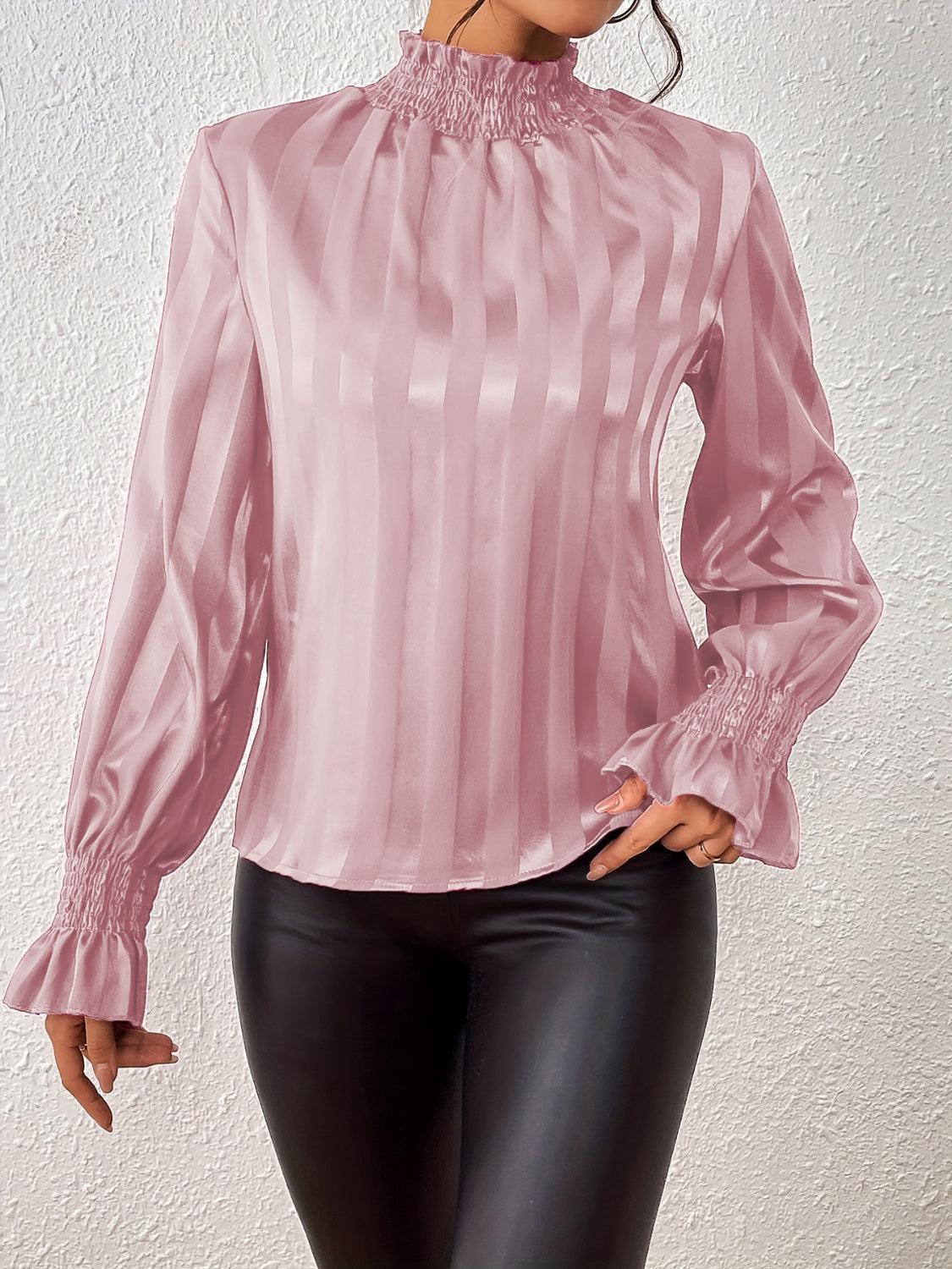 a woman wearing a pink blouse and black pants