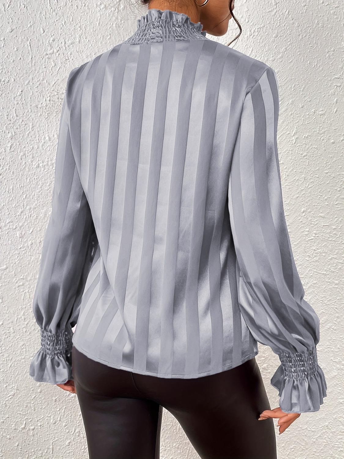 a woman wearing a gray and white striped blouse