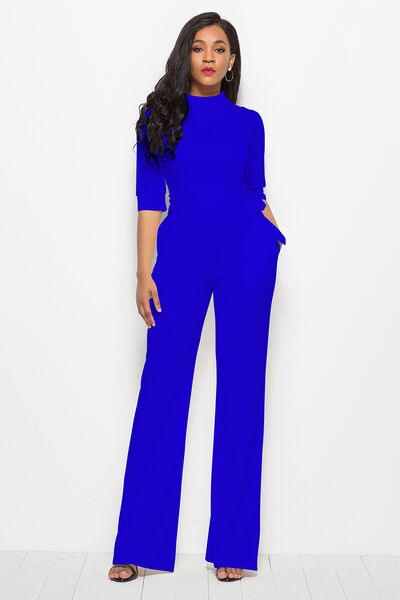 a woman in a blue jumpsuit posing for a picture