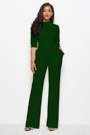 a woman in a green jumpsuit posing for a picture