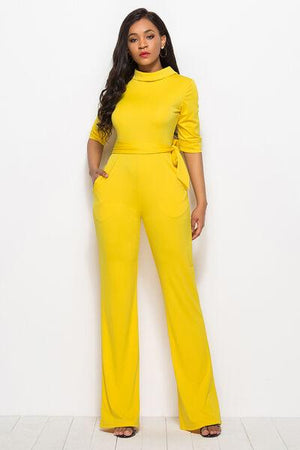 a woman in a yellow jumpsuit posing for a picture