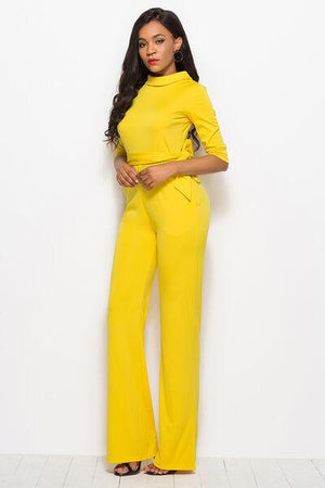 a woman in a yellow jumpsuit posing for a picture