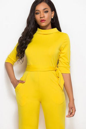 a woman in a yellow jumpsuit posing for a picture