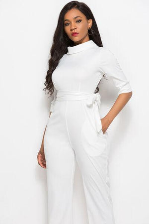 a woman in a white jumpsuit posing for a picture