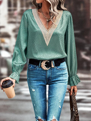 a woman wearing a green blouse and ripped jeans