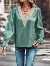 a woman wearing a green blouse and jeans