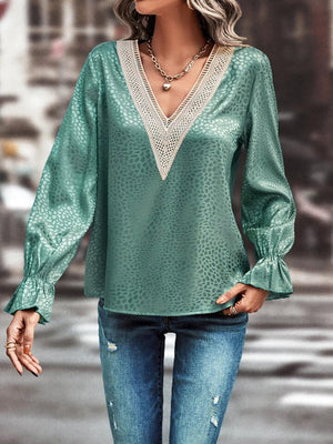 a woman wearing a green blouse and jeans