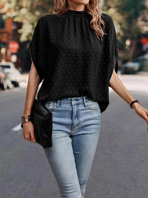 a woman walking down the street wearing jeans and a black top