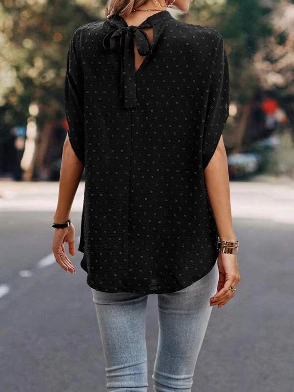 a woman walking down a street wearing a black shirt and jeans