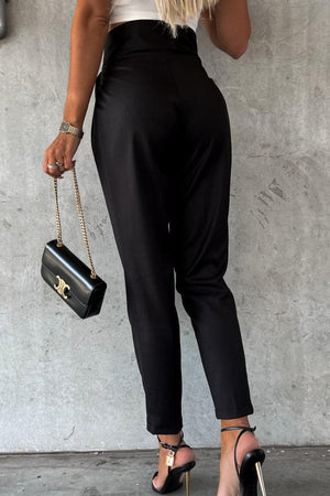 a woman in high heels holding a black purse