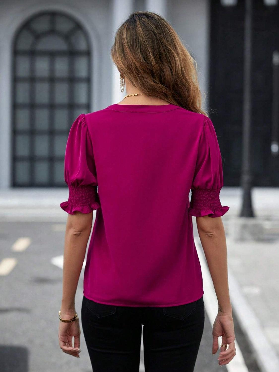 a woman walking down a street wearing a pink top