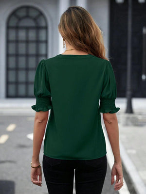 a woman in a green top is walking down the street