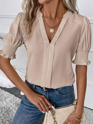 a woman wearing a beige blouse and jeans