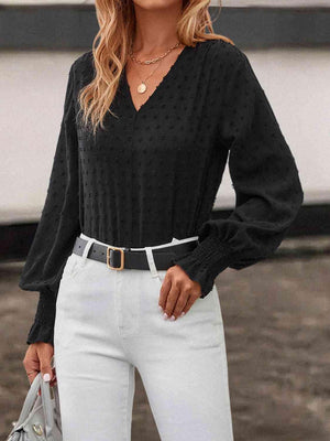 a woman wearing a black sweater and white pants