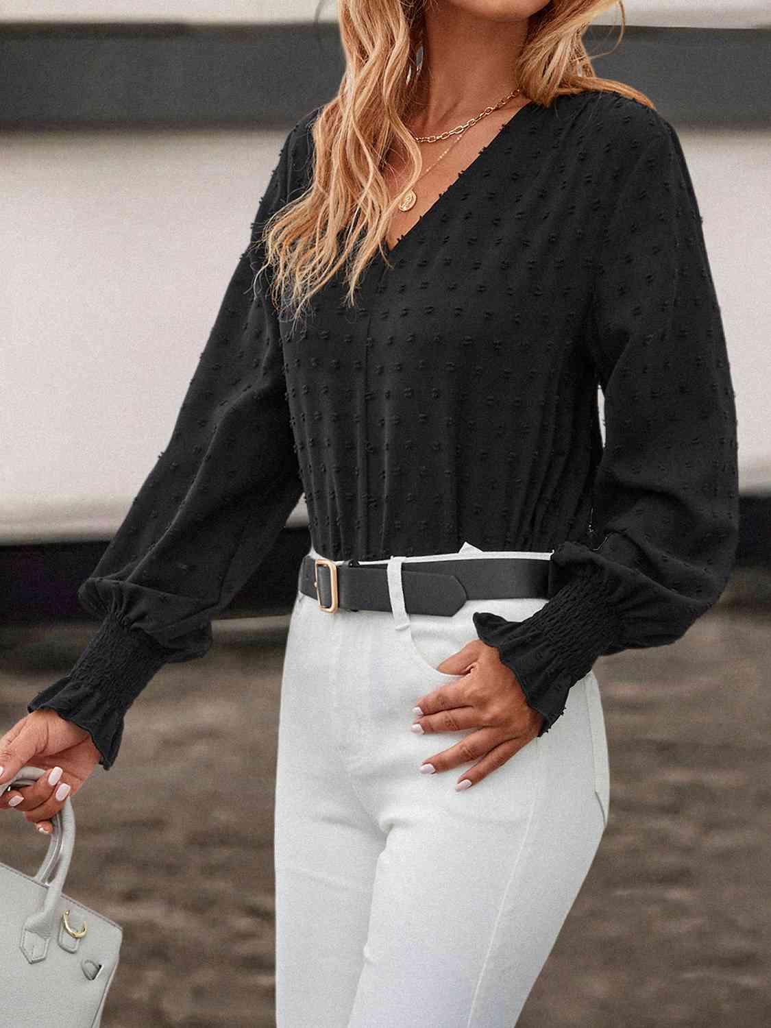 a woman wearing a black top and white pants