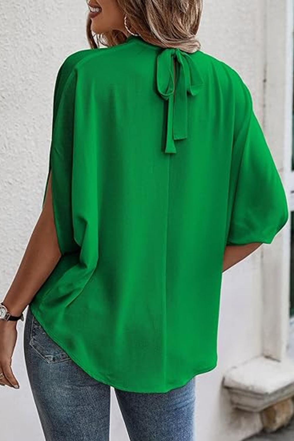 a woman wearing a green blouse and jeans