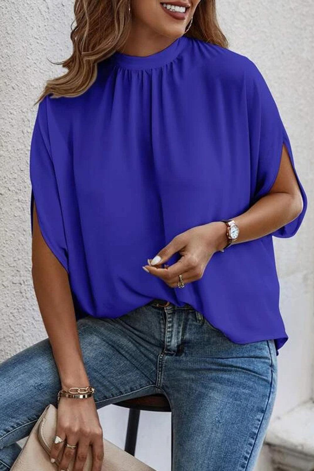 a woman sitting on a chair wearing a blue top