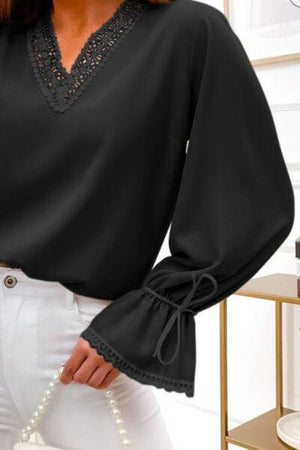 a woman wearing a black blouse and white pants