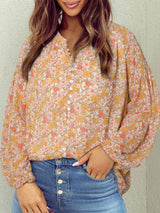 a woman wearing a floral blouse and jeans